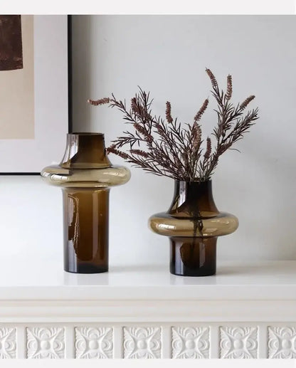 Two amber artisan glass vases with modern bulbous design on white surface for elegant decor use