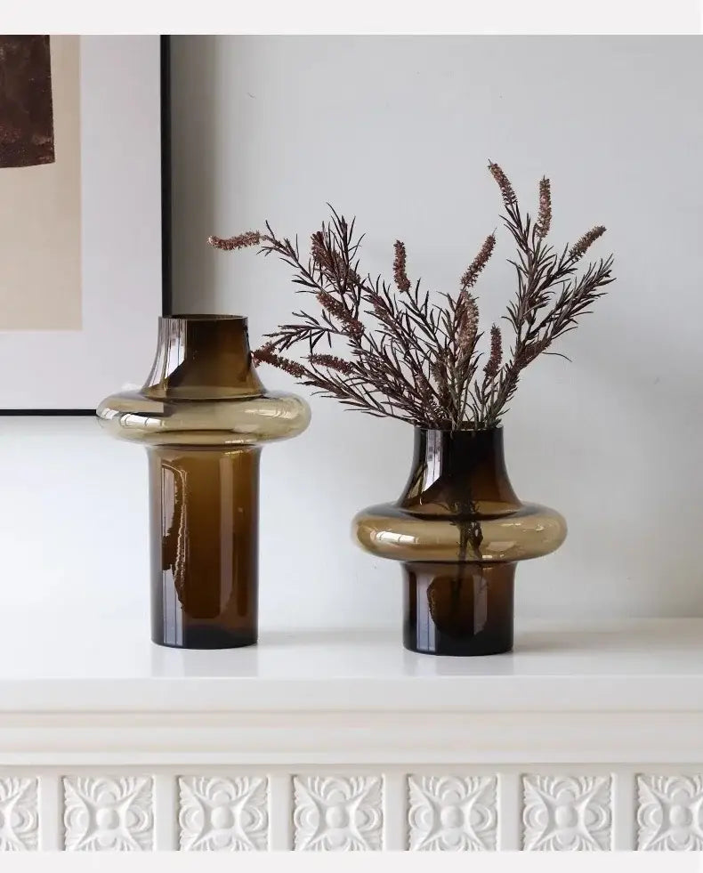 Two amber artisan glass vases with modern bulbous design on white surface for elegant decor use