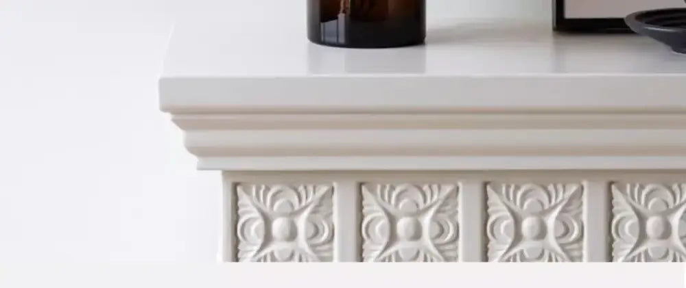 White fireplace mantel with ornate carved panels showcasing artisan glass vase elegant decor for art glass display