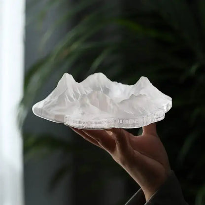 Artistic translucent white decorbites iceberg glass dessert plate shaped like a mountain range with intricate ridges