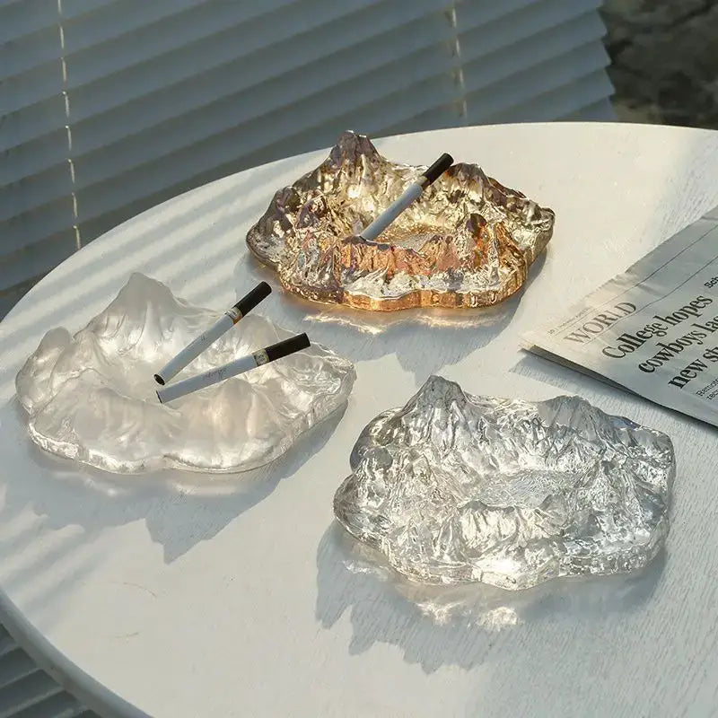 Artistic clear and gold decorbites iceberg glass dessert plate featuring three mountain-shaped ashtrays in translucent and metallic finishes