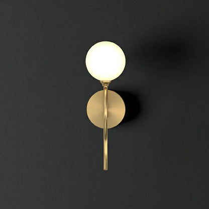Artistic gold spherical wall lighting fixture with frosted glass globe and minimalist metallic base for bedroom use