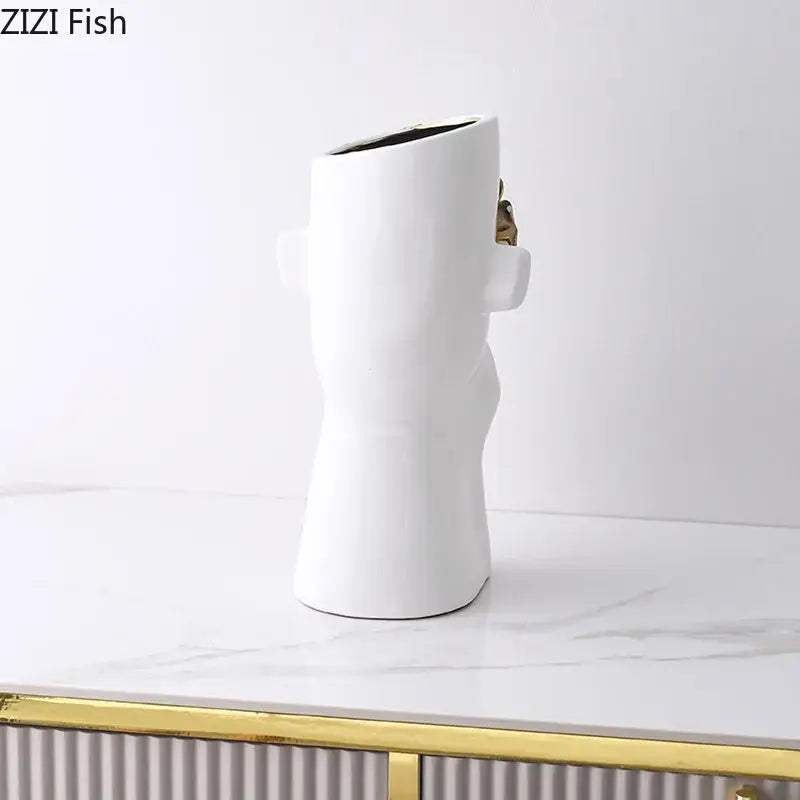 Artistic white ceramic vase shaped like a stylized human figure with gold rose relief accents for bedroom decor