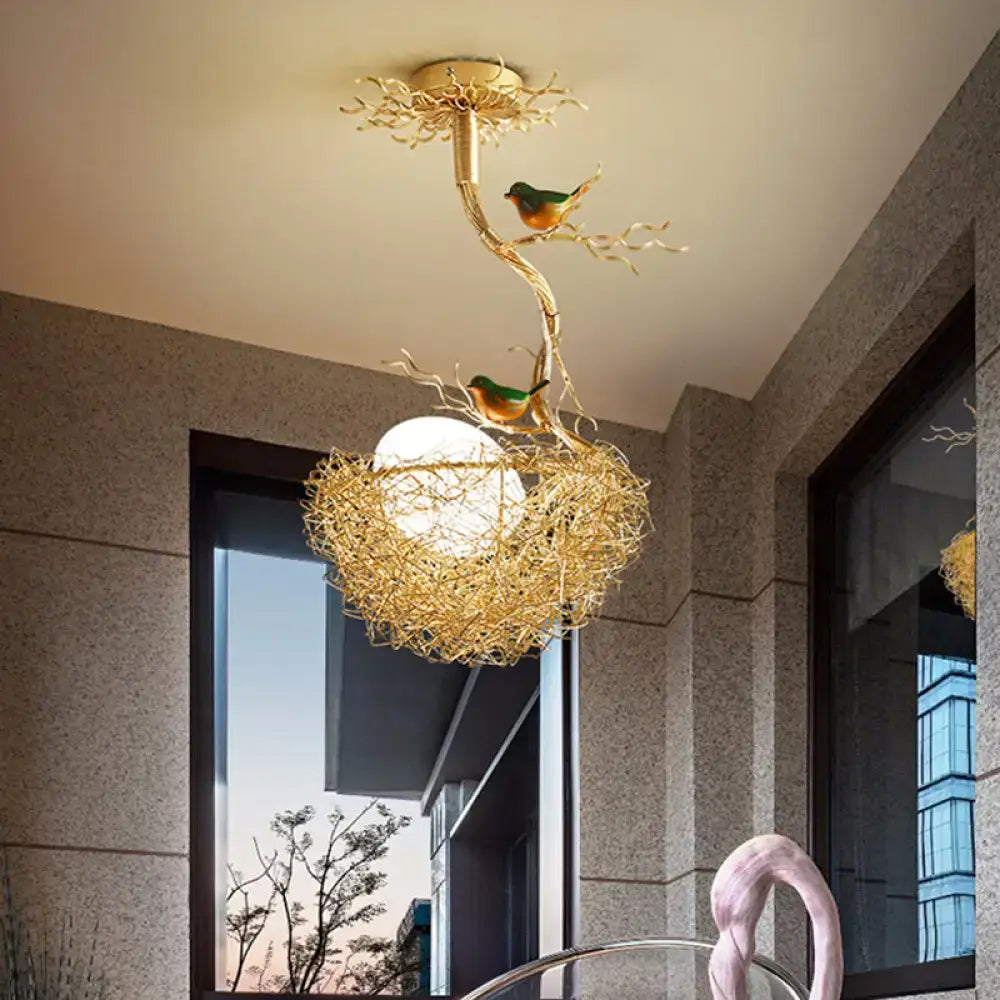 Golden bird-themed ceiling light with milk white glass ball and hand-sewn aluminum nest in decorbites artistry pendant