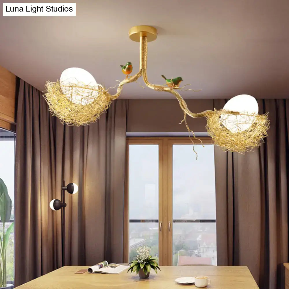 Golden bird’s nest chandelier with milk white glass ball and two perched birds in hand-sewn aluminum nest design