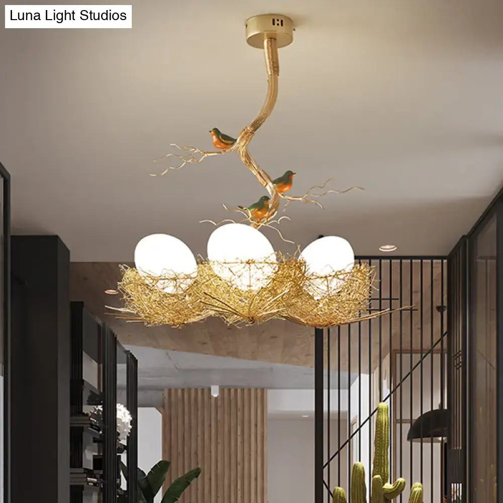 Golden bird-themed chandelier with milk white glass ball bulbs nestled in a hand-sewn aluminum nest pendant lamp