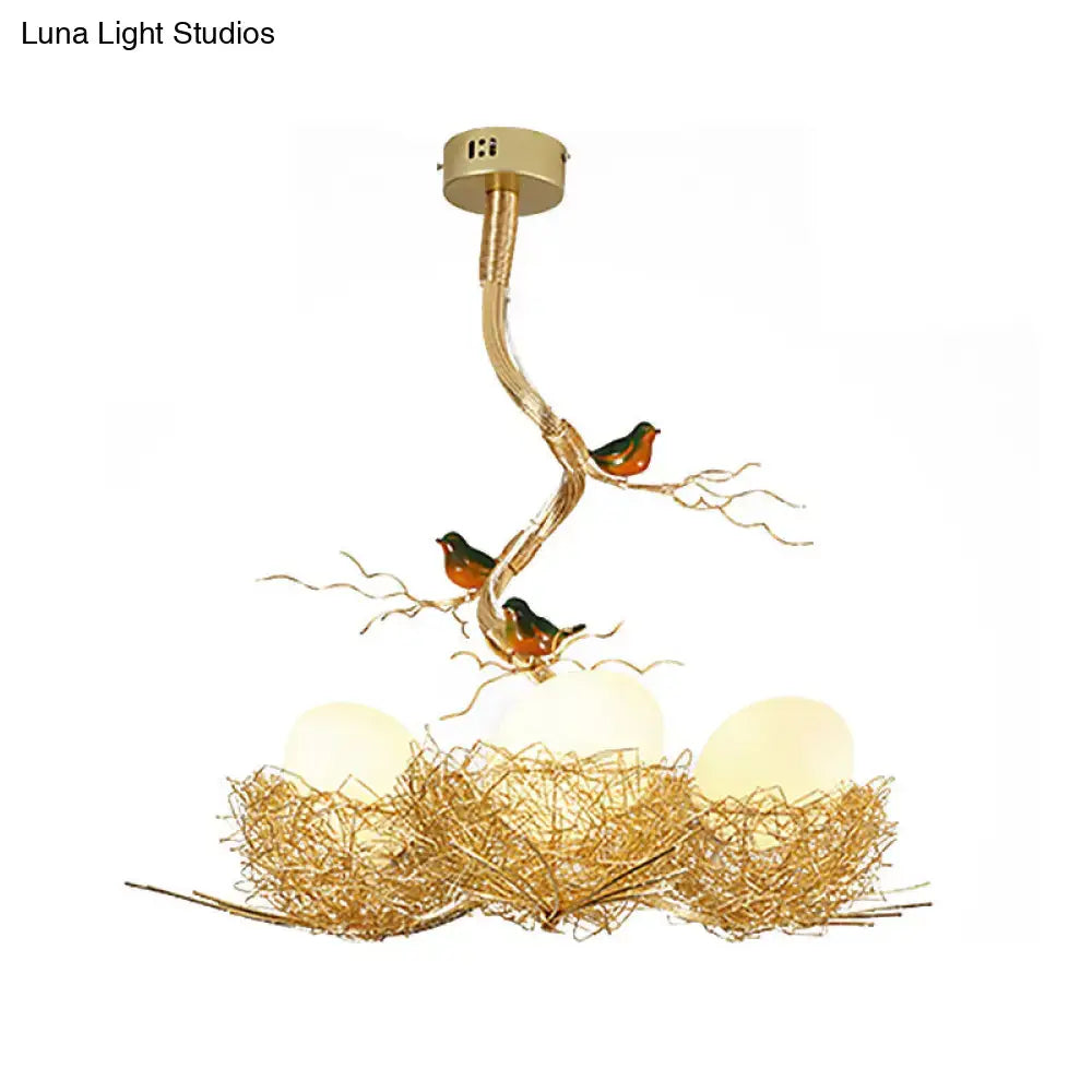 Gold-toned DecorBites™ chandelier with milk white glass ball bulbs and intricate bird-themed hand-sewn aluminum nest design