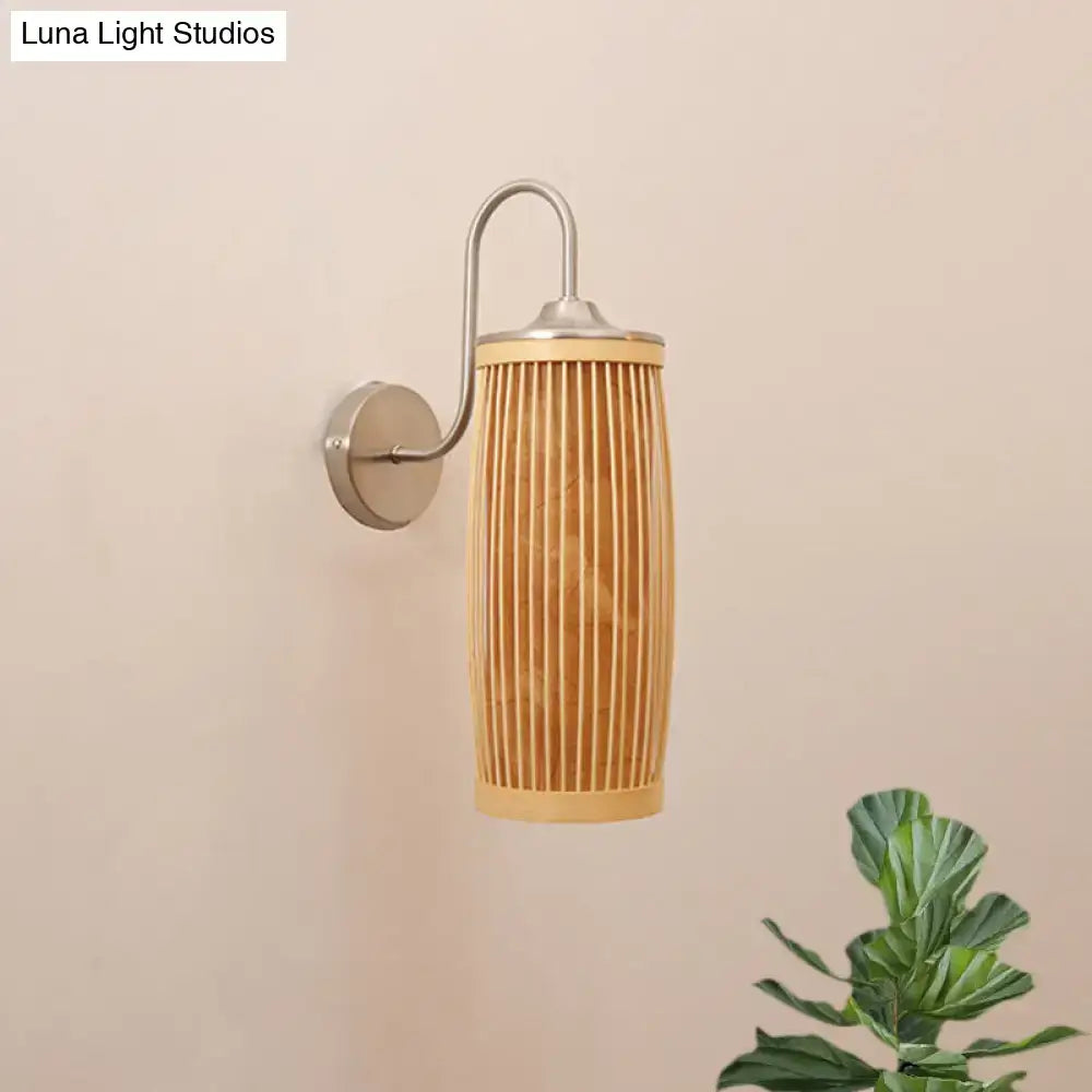 A sleek wall lamp with a cylindrical bamboo shade and brushed metal hardware featuring a gooseneck arm