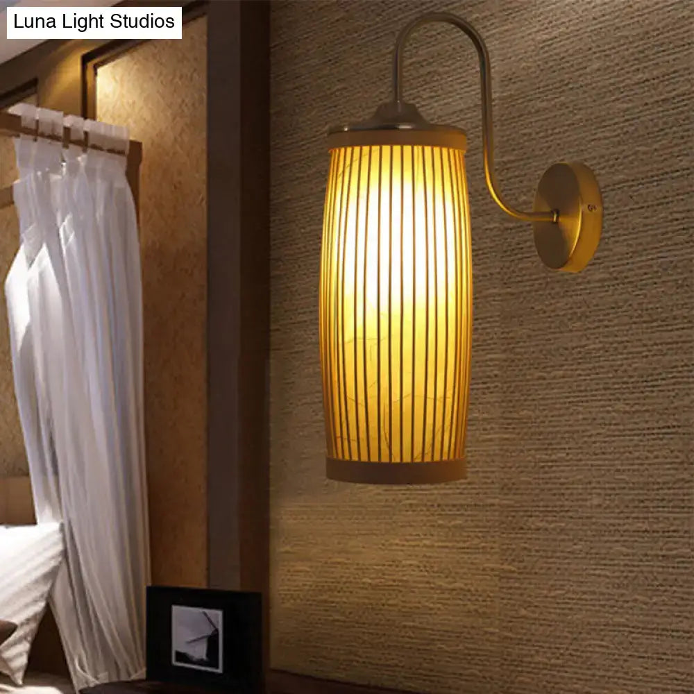 Warm-toned asian bamboo and brass wall lamp with gooseneck arm featuring vertical bamboo slats for bedroom lighting