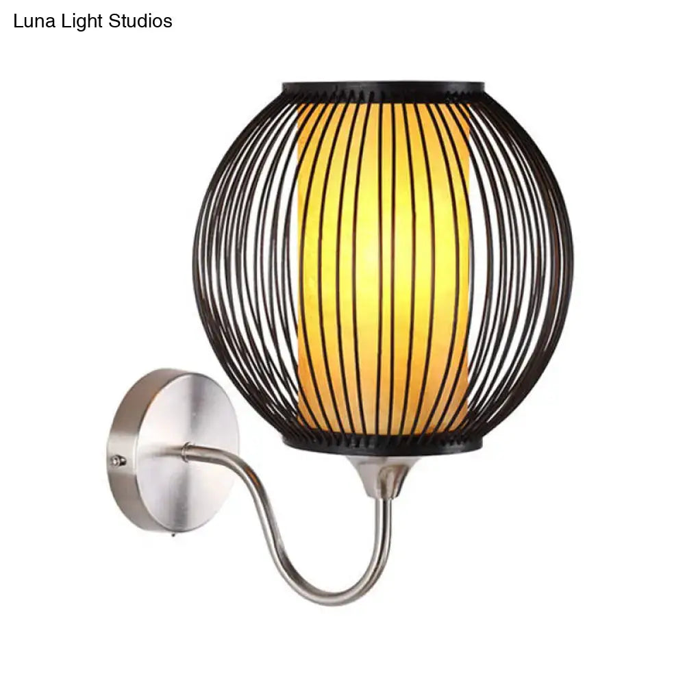 Asian style black bamboo wall lamp with gooseneck arm featuring a black wireframe spherical wall light and warm glass panel