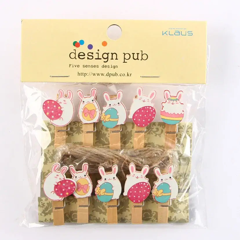 Cute wooden clip featuring a white bunny holding an easter egg with pink and teal eggs on colorful paper decor