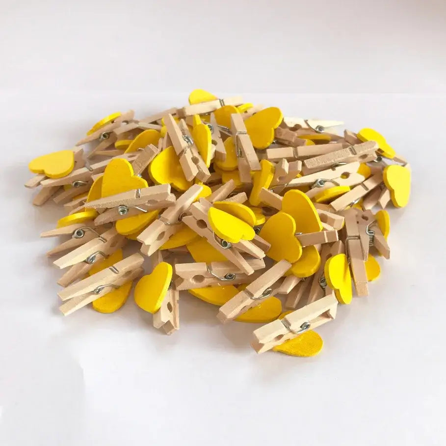 Yellow heart-shaped mini wooden clips with natural wood bodies for bedroom photo decor and crafts use