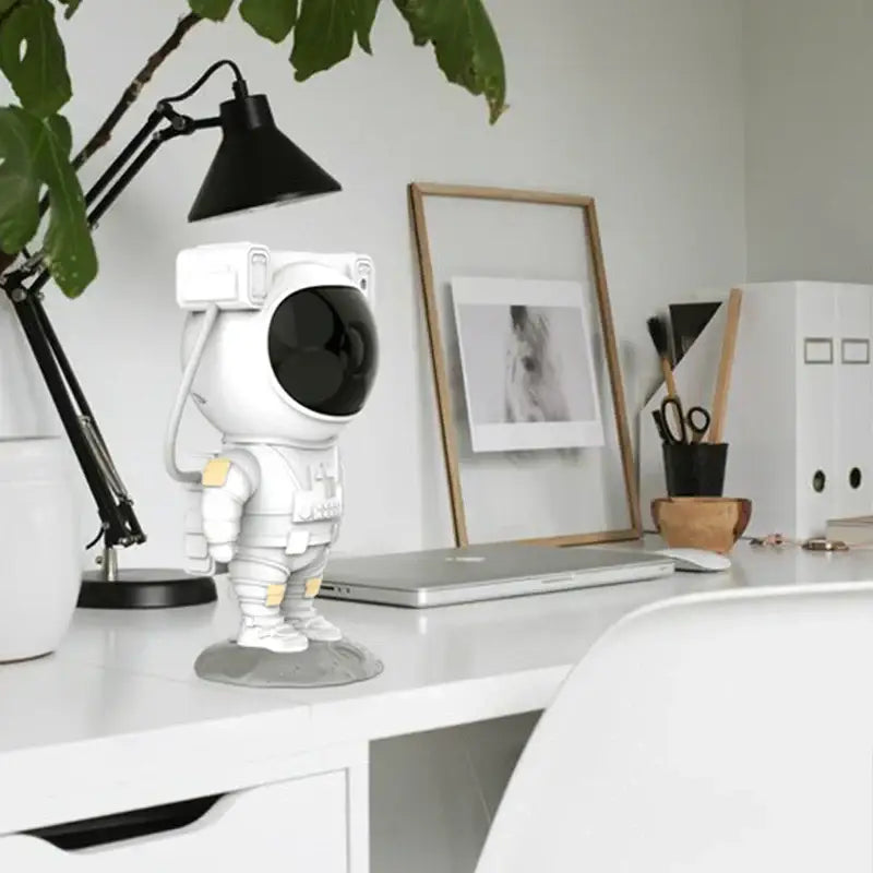 Decorbites astronaut sky projector nightlight in white and gold shaped as a playful astronaut desk lamp with yellow accents