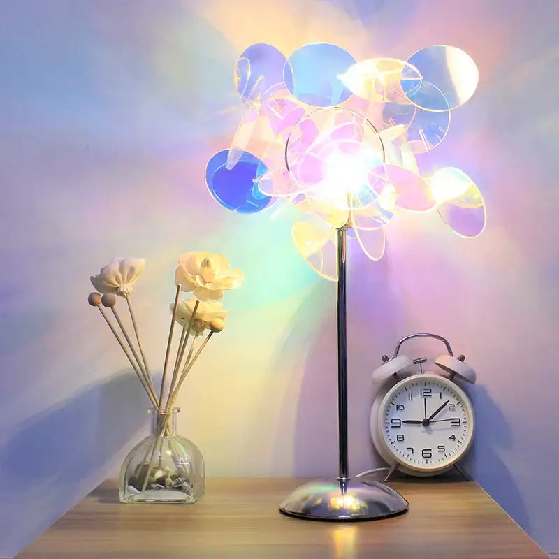 Aurora acrylic projection lamp with slender metallic base and iridescent blue and purple acrylic shade for bedroom use