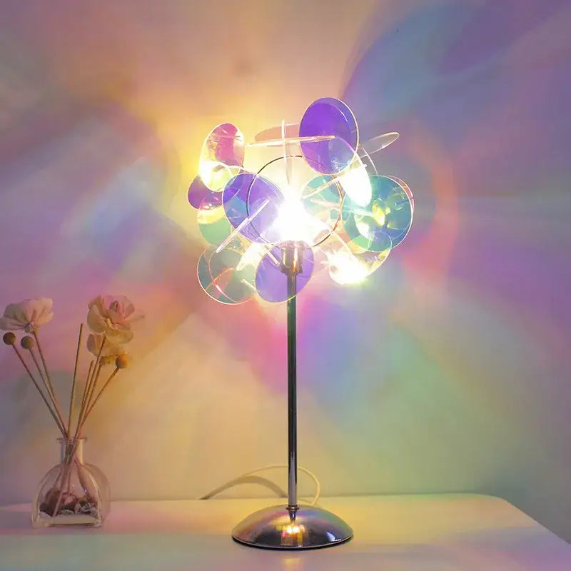 A modern aurora acrylic projection lamp with slender metallic stand and iridescent blue and purple glass discs