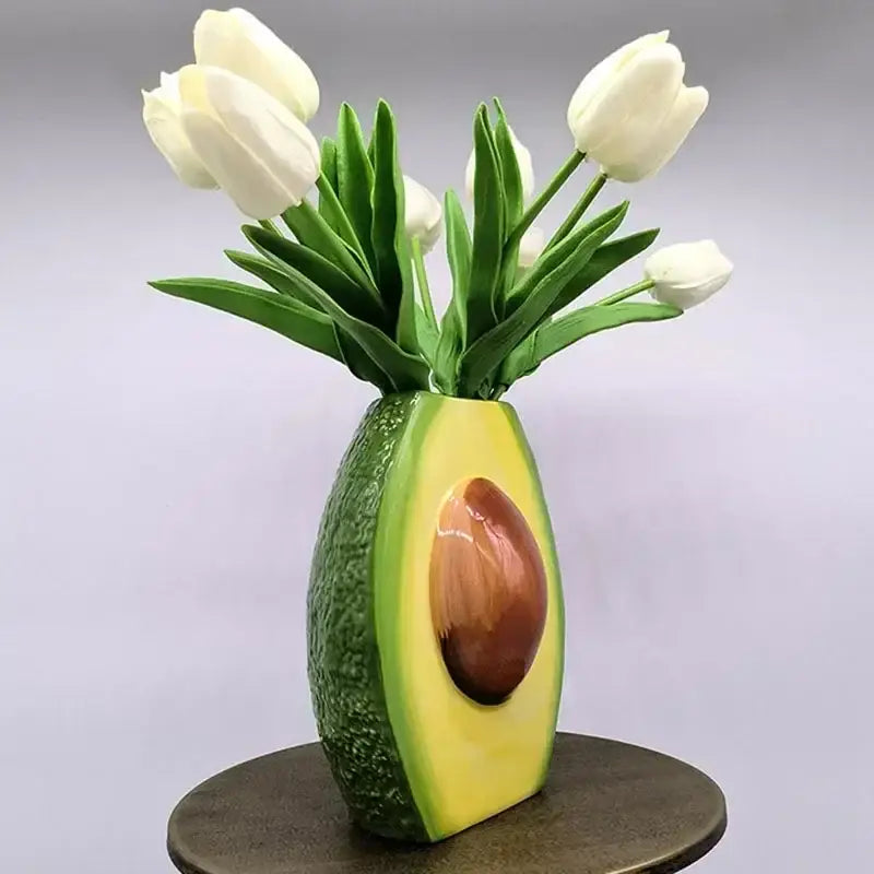 Glossy avocado ceramic vase shaped like a half avocado with textured green skin and yellow flesh for home decor