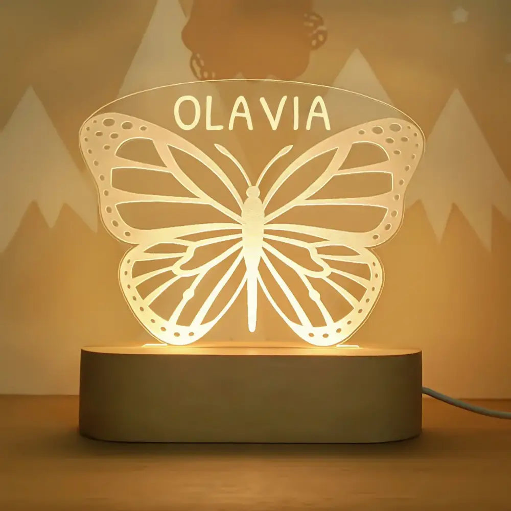 A warm glowing butterfly-shaped led night light personalized with the name olavia for baby kids nursery decor