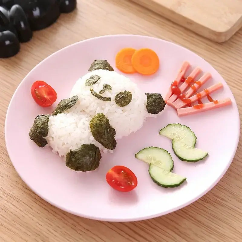 A white rice baby panda sushi shaped with seaweed, cherry tomato, carrot, cucumber, and ham using panda sushi mold