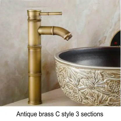 Antique brass basin mixer tap with bamboo-inspired design and three sections for bathroom basin use