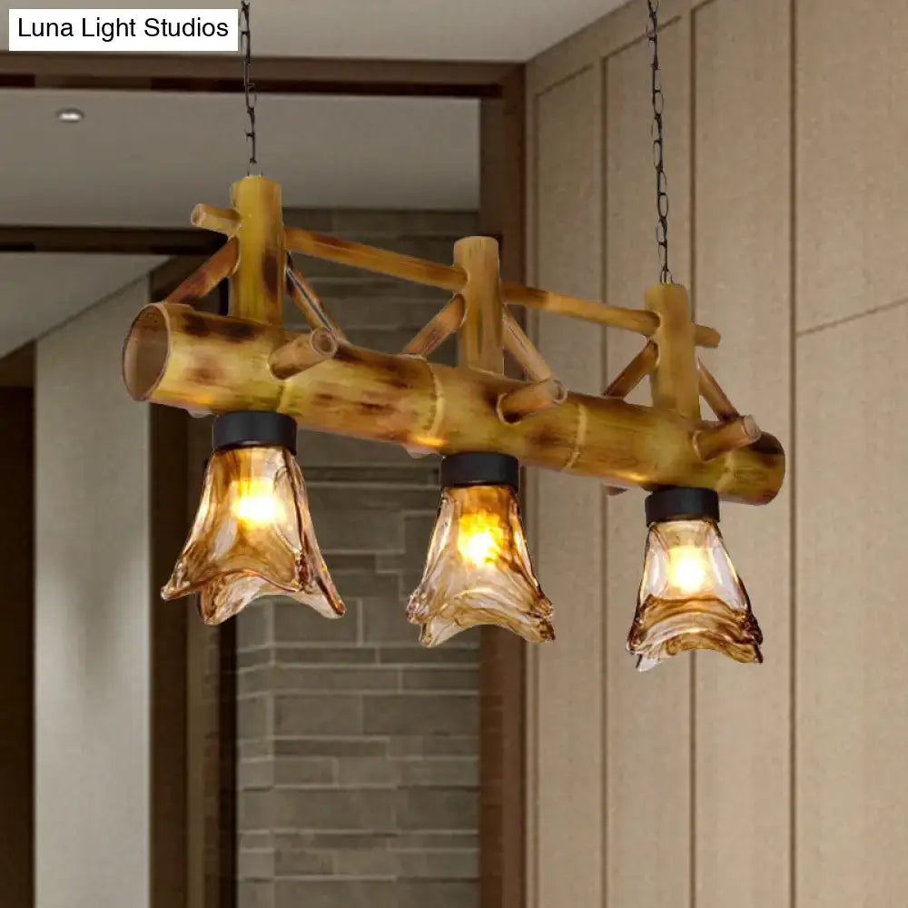 DecorBites™ bamboo lodge pendant light with three amber glass shades and black metal accents for island lighting