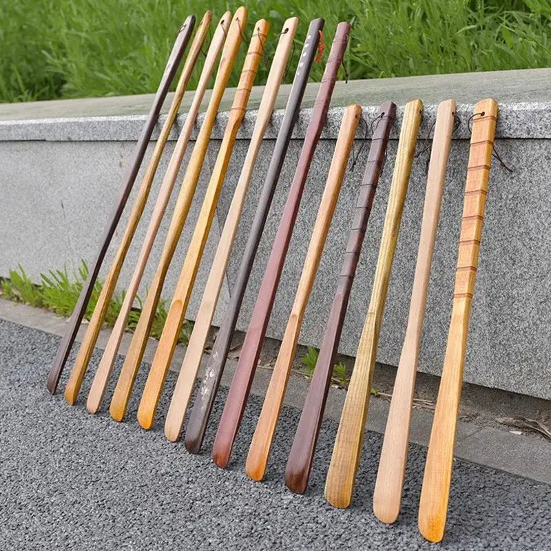 A collection of wooden long handle shoe lifters with bamboo pattern and smooth finish in natural and stained hues