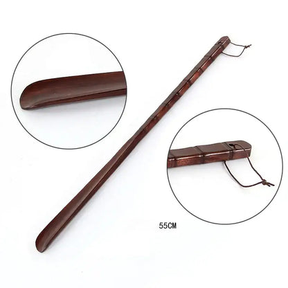 A polished dark brown wooden shoe lifter with bamboo pattern long handle for bedroom dressing aid and easy insertion