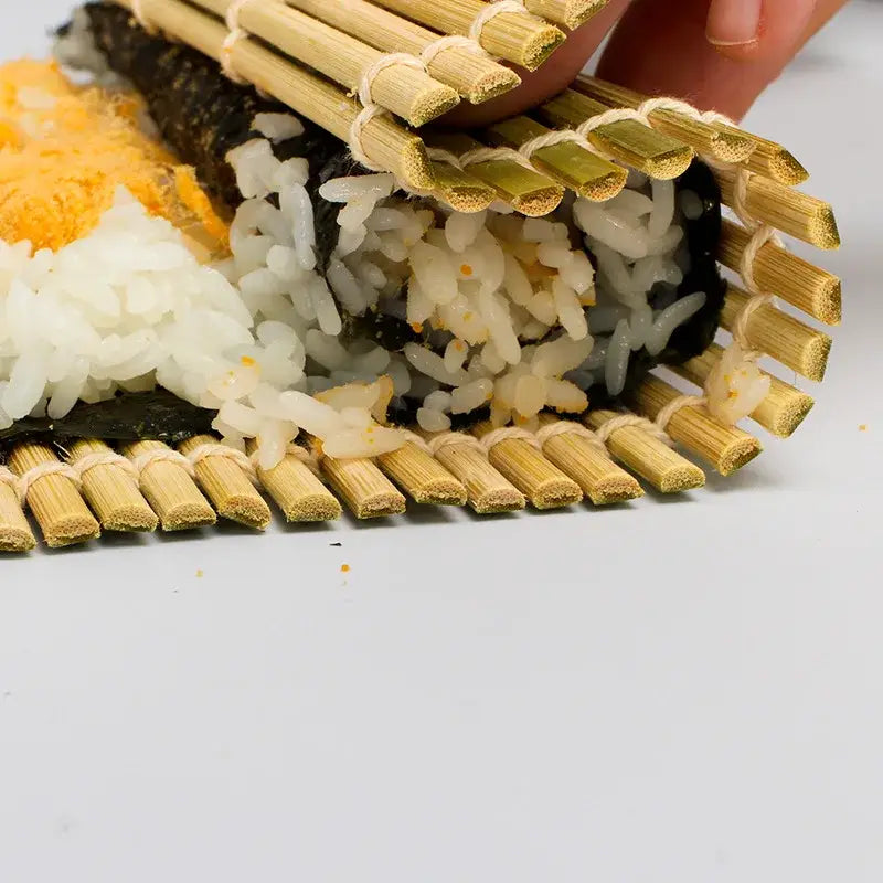 Natural bamboo sushi rolling mat with woven slats and light tan finish for sushi rolling and onigiri rice paddles