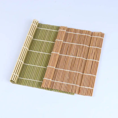 Two bamboo sushi rolling mats in natural tan and olive green with white string bindings for sushi rolling and onigiri rice paddles