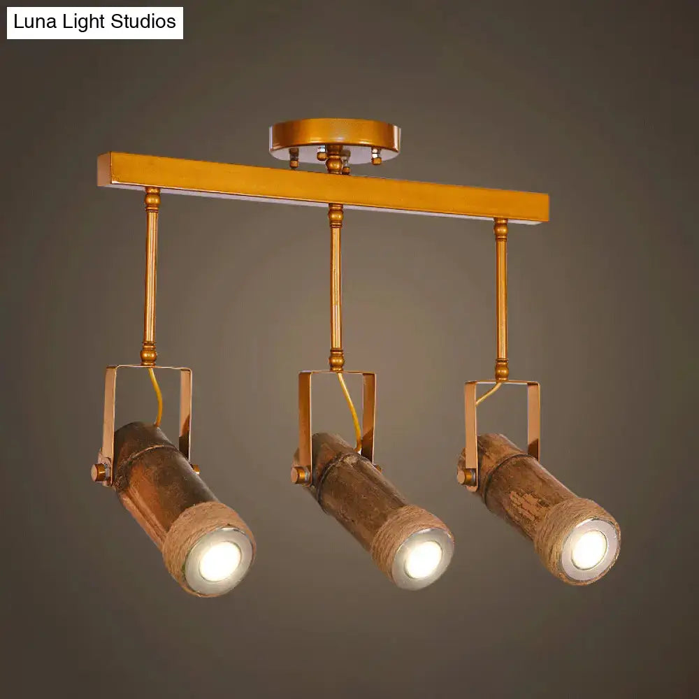 Gold-toned DecorBites™ bamboo tube island pendant with three led light spotlights wrapped in rustic hemp rope suspension