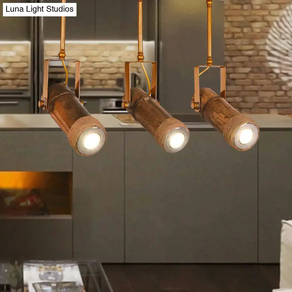 Three rustic copper-toned bamboo tube pendant lights with exposed led light bulbs and hemp rope accents