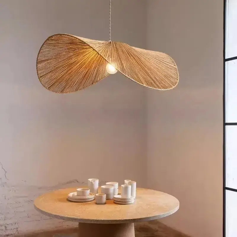 A warm golden-brown bamboo wabi sabi pendant light with woven rattan leaf design for dining room lighting