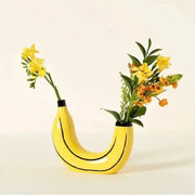 Yellow banana shape resin flower vase with black curved lines and black rim for decorative use