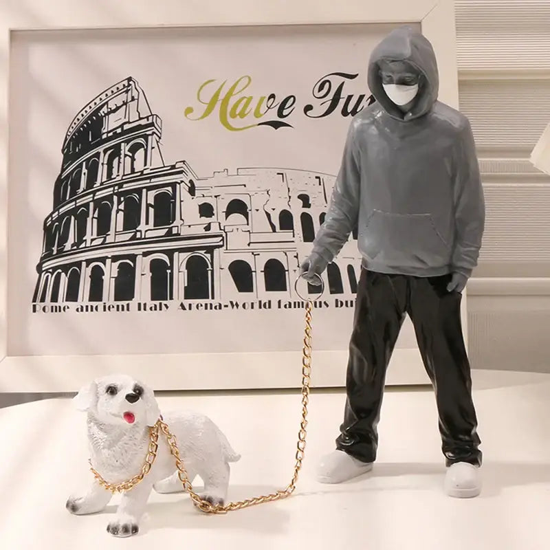 Gray hooded figure banksy dog walker resin statue holding gold leash attached to white dog for living room decor