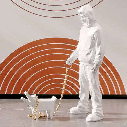 White resin banksy dog walker figurine with hooded person walking small dog on gold chain leash for living room decor