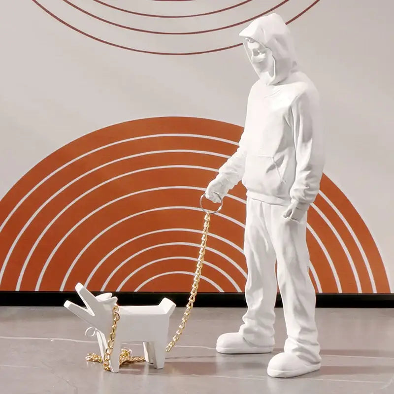White resin banksy dog walker figurine with hooded person walking small dog on gold chain leash for living room decor