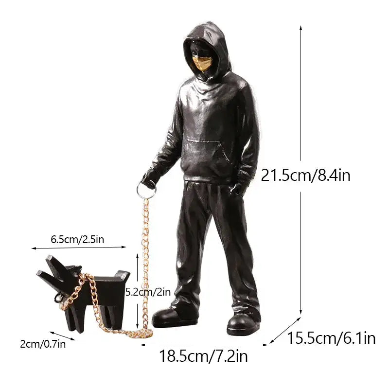 Black glossy hooded figure with gold mask holding leash and small black dog from banksy sculpture collection decor
