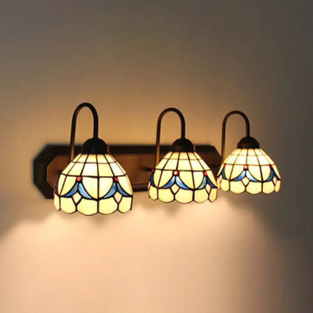 Aplique de pared barroco con cúpula de cristal beige e iluminación con diseño floral de tres luces en negro.