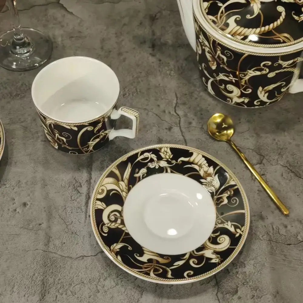 Black and gold ornate porcelain teacup with white interior and decorative handle from black unicorn series kitchenware