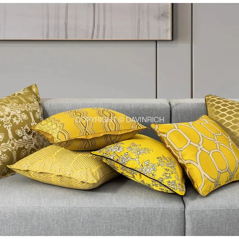 A collection of vibrant yellow cushion covers with intricate gold and white baroque floral geometry patterns for decorbites living room decor