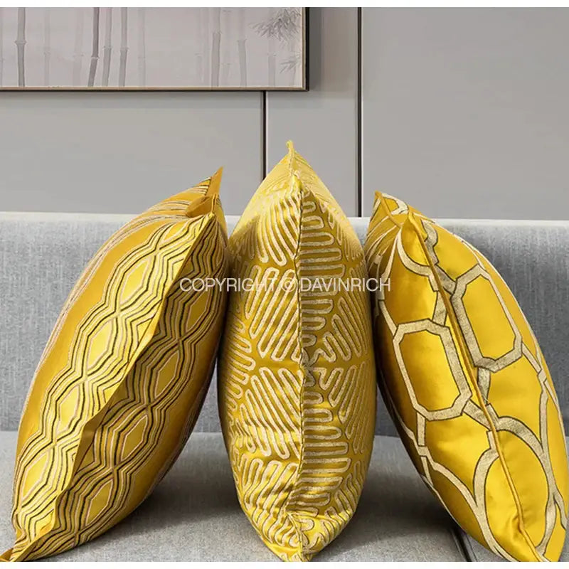 Three vibrant yellow decorbites baroque floral cushion covers with metallic gold baroque floral geometry on gray sofa