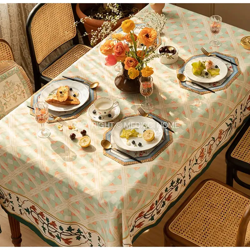 A delicate mint green decorbites baroque flowers fringe placemat with geometric pattern and peach floral border