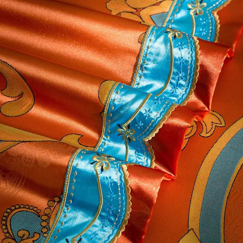 Vibrant orange satin bedding set with intricate blue and gold embroidered trim in 200s embroidery cotton fabric