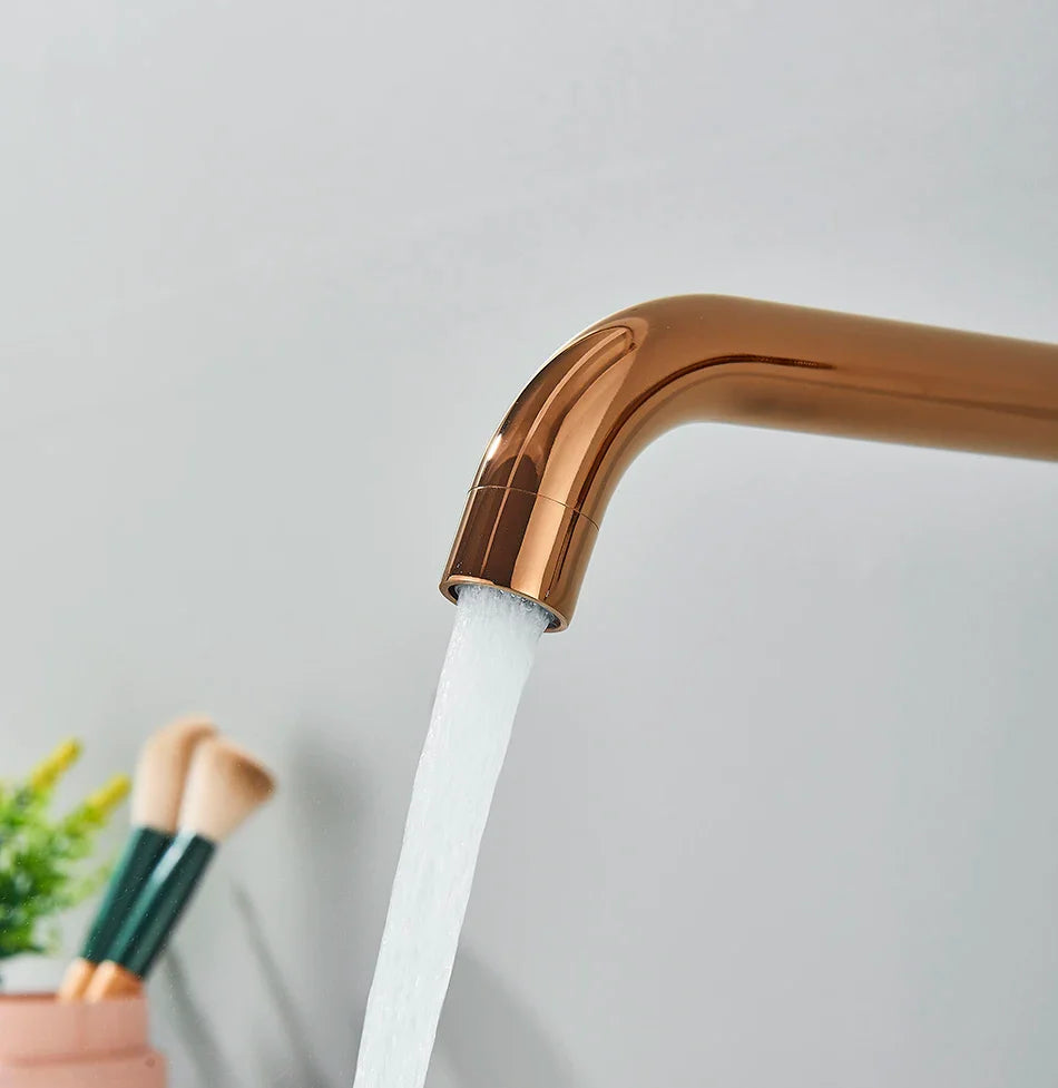A sleek rose gold basin faucet wall mounted bathroom with modern curved design and hot water control features