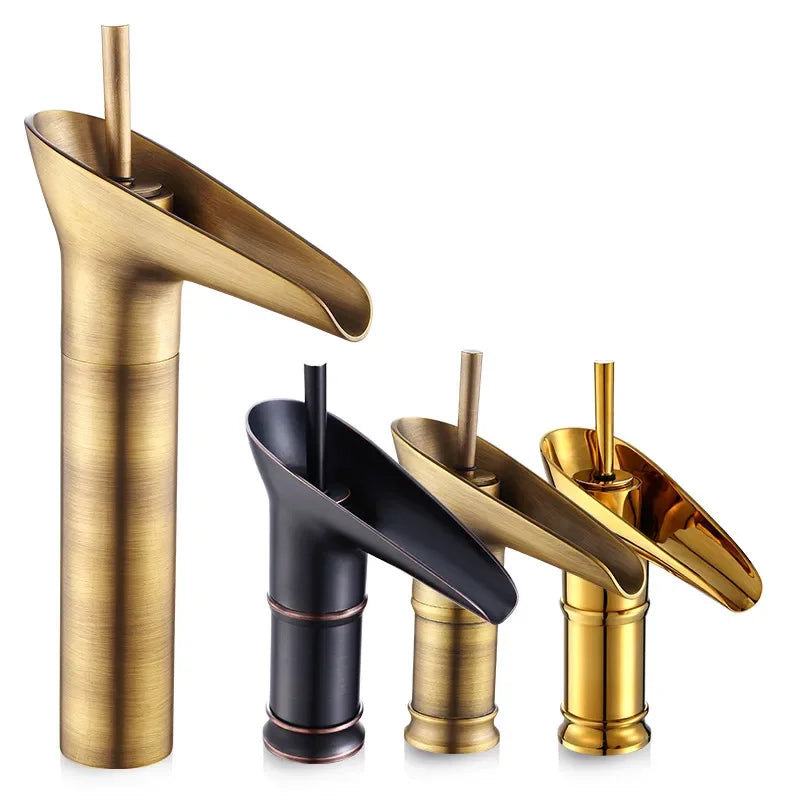 Gold-toned antique brass waterfall bathroom faucet with brushed metal finish featuring deck mounted metered valve control