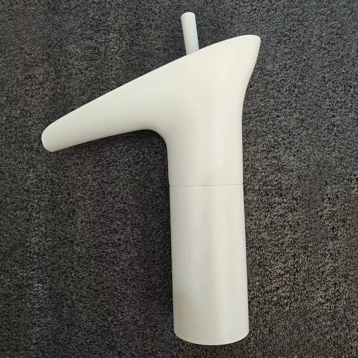 White plastic bathroom faucet with sleek modern design deck mounted featuring metered valve control and smooth curves