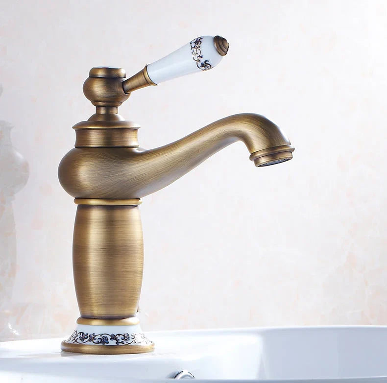 Antique bathroom faucet with bronze finish featuring white ceramic handle with black floral patterns and decorative base