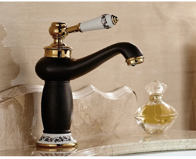 Bathroom faucet with black matte finish, gold accents, white ceramic handle, and ornate black detailing in bronze finish