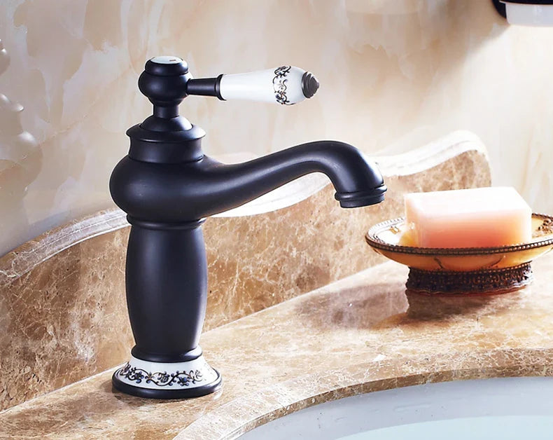 Black matte bathroom faucet with bronze finish white ceramic handle and decorative floral patterns