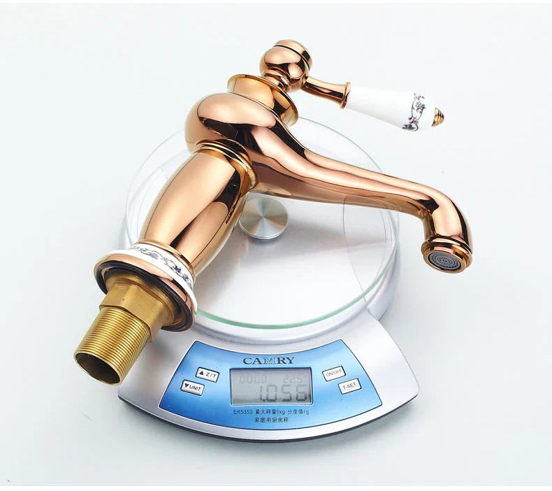 Rose gold vintage-style bathroom faucet with white ceramic handle and black detailing in antique bronze finish