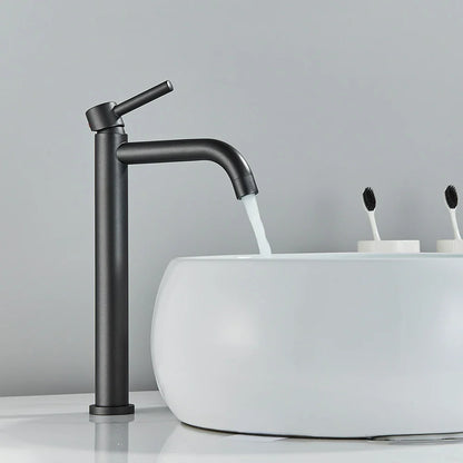 Black matte bathroom faucet with a sleek, tall design and curved spout in brushed gold mixer tap style